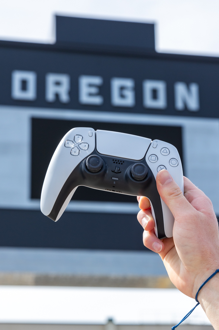 Playstation 5 is one of the two consoles where people can play NCAA 25. A Playstation 5 controller is held outside Autzen Stadium in Eugene, Ore. (Molly McPherson/Emerald)