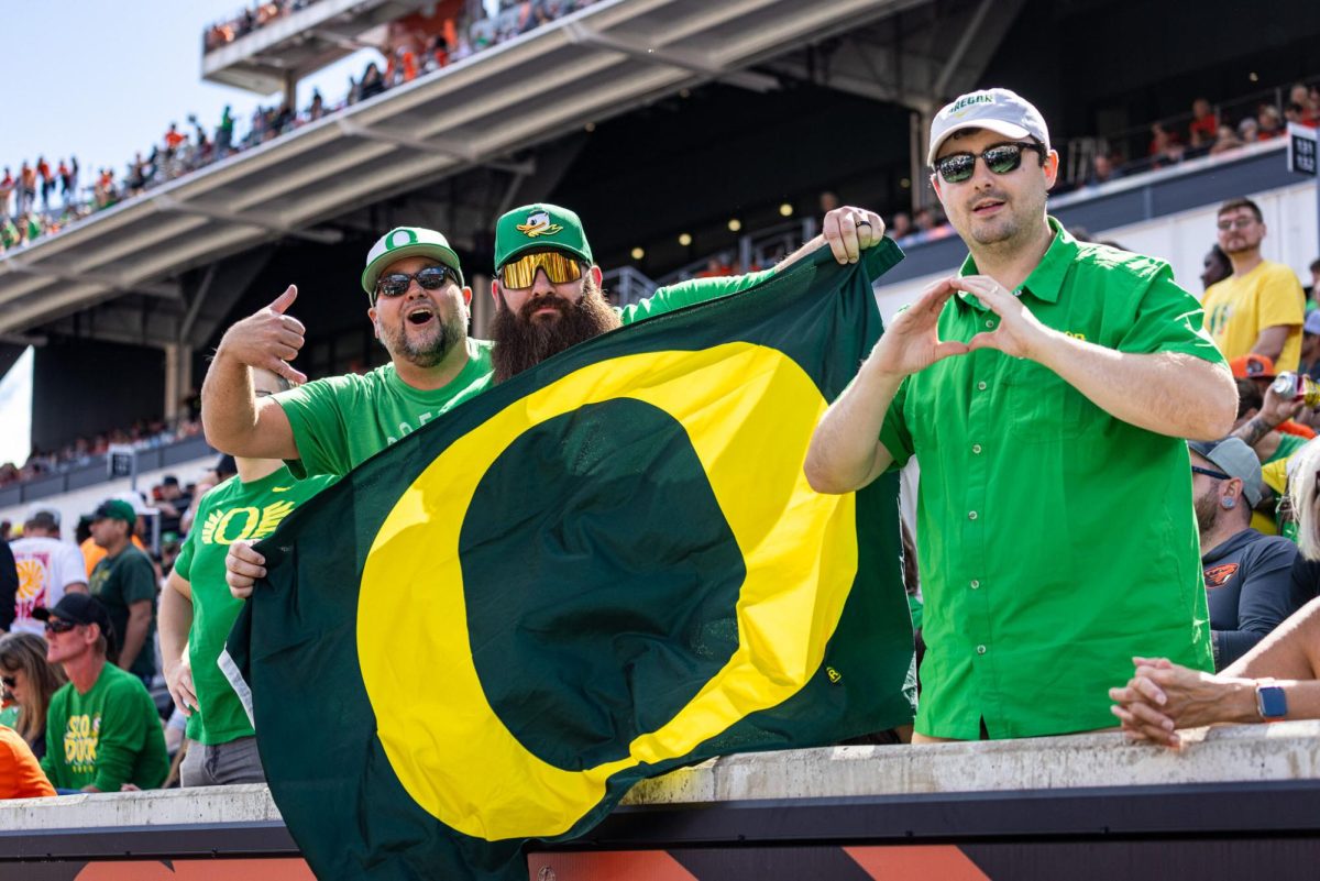 A group of Duck fans show off their Oregon flag as the Ducks quite the Beaver fans in the stadium with an impressive performance. The Oregon Ducks travel up to Corvallis to face their in-state rival the Oregon State Beavers on September 14th, 2024. (Jonathan Suni/Emerald)