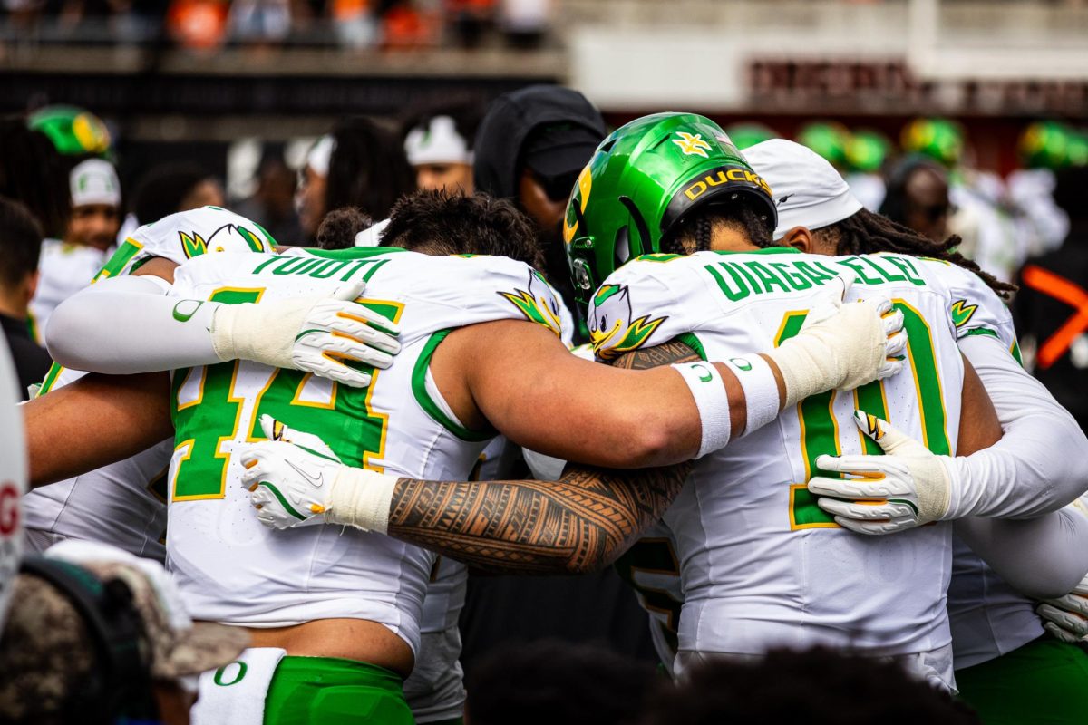 The outside linebacker group prays on the sideline as the Ducks prepare to kick off. The Oregon Ducks travel up to Corvallis to face their in-state rival the Oregon State Beavers on September 14th, 2024. (Jonathan Suni/Emerald)