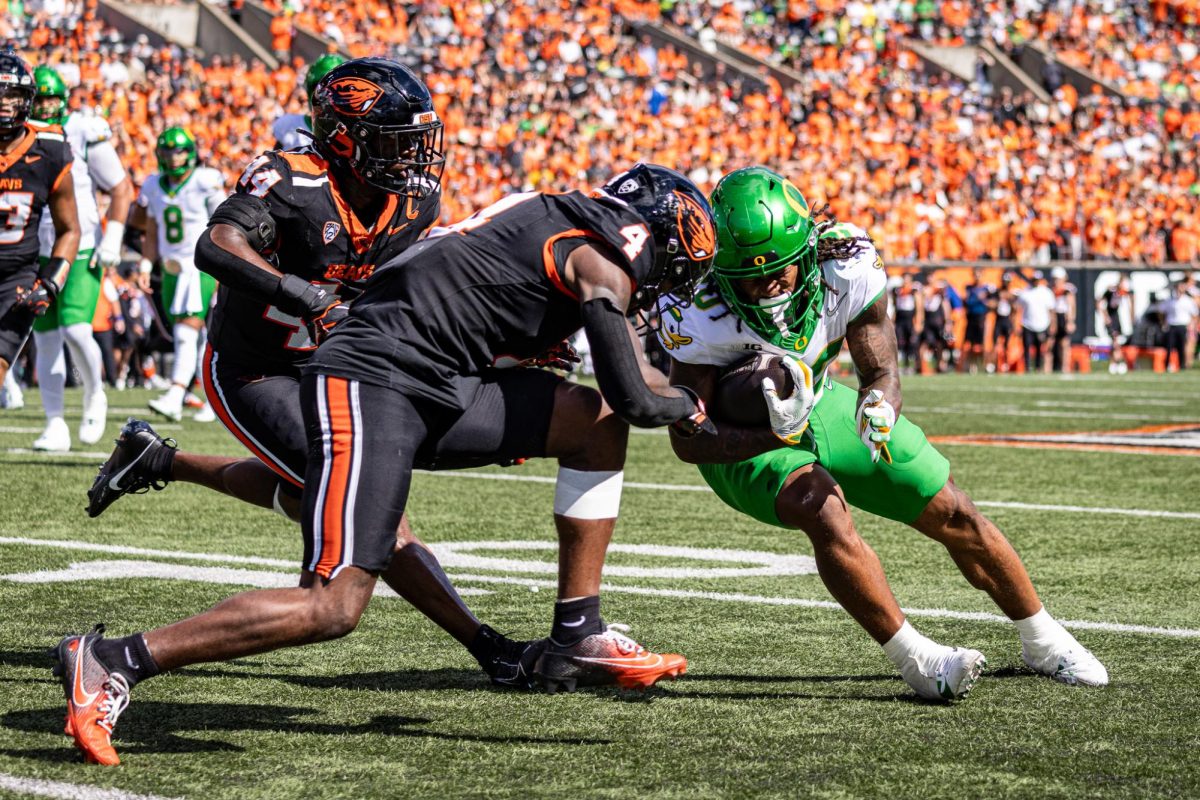 Oregon running back, Jordan James (20), lowers his helmet to take on a big hit by an Oregon State defender. The Oregon Ducks travel up to Corvallis to face their in-state rival the Oregon State Beavers on September 14th, 2024. (Jonathan Suni/Emerald)