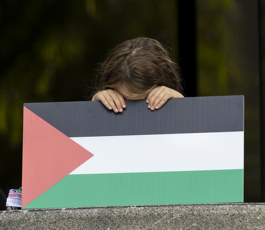 Sigrun Trewe—a family member of Jacob Trewe, one of the defendants facing charges—holds a Palestinian flag sign in from of their face at the demonstration on Sep. 23, 2024. People gathered at the Wayne L. Morse Free Speech Plaza in support of the 