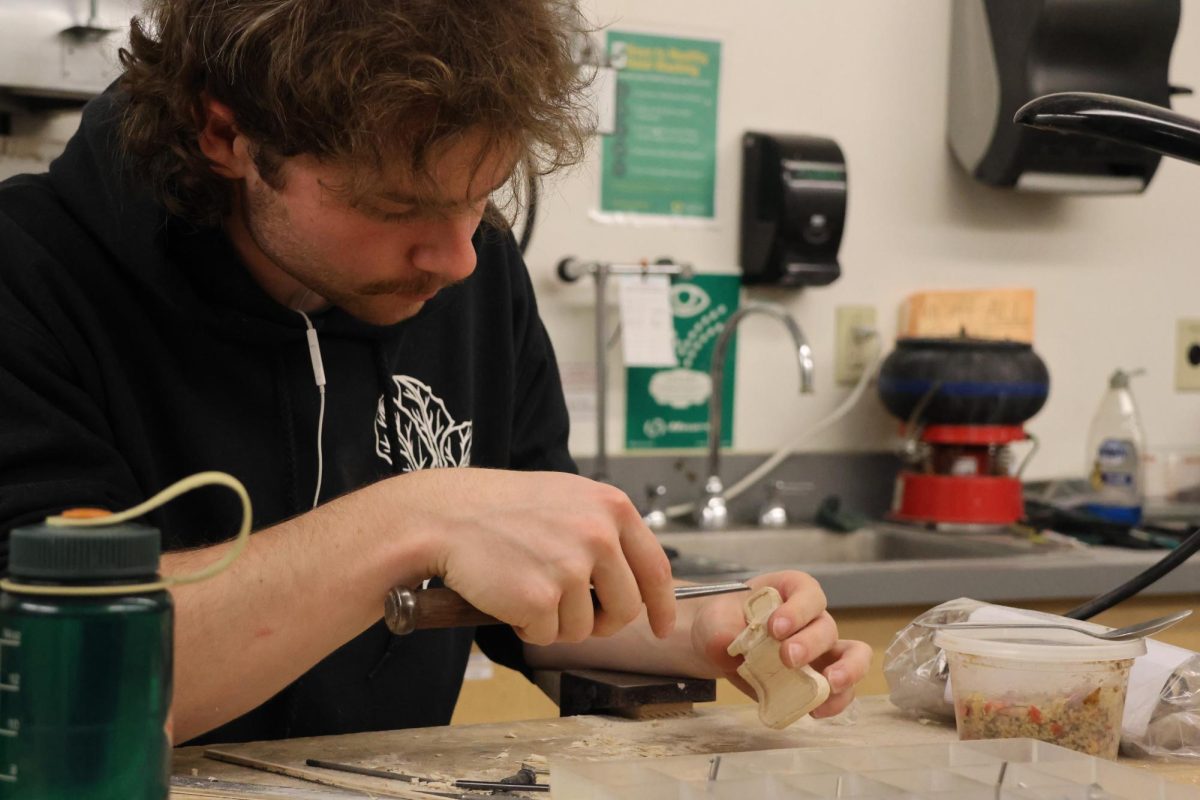 Calder Muller crafts a wooden replica of a metal piece at the Erb Memorial Union’s Craft Center. Muller is part of an industrial production and globalization class and plans to use the wooden piece in an upcoming ceramic model. (Julia Massa/Emerald)