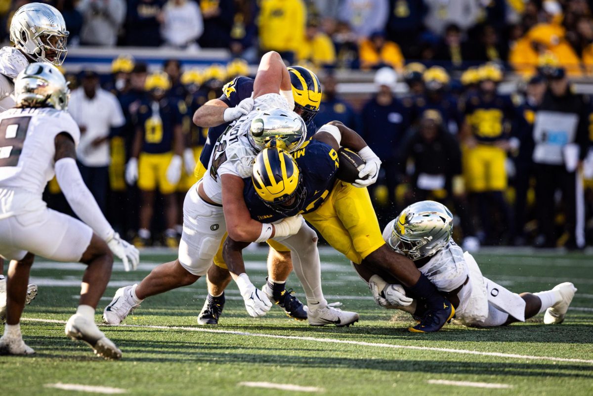 The Oregon defense closes a running lane for the Michigan offense. The No. 1 Oregon Ducks beat the Michigan Wolverines 38-17. (Jonathan Suni/Emerald)