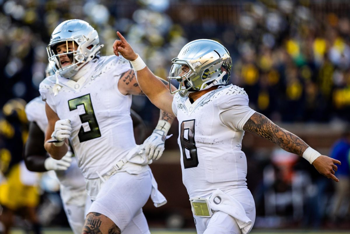 Dillon Gabriel (8) runs to the sideline to celebrate his rushing touchdown with the rest of his team. The No. 1 Oregon Ducks beat the Michigan Wolverines 38-17. (Jonathan Suni/Emerald)