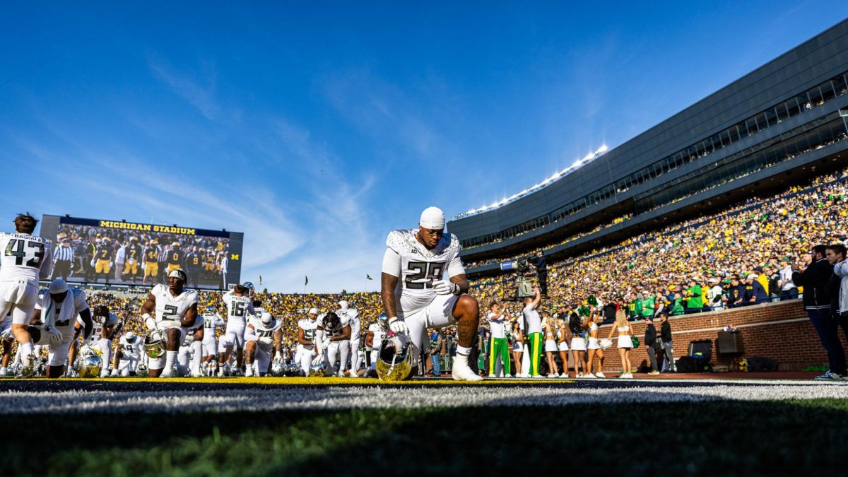 Ashton Porter (29) prays in the endzone prior to the game. His mother passed away earlier this year who he honors with a message on his eye black tape. The number 1 ranked Oregon Ducks takes on the Michigan Wolverines on Nov. 2, 2024, at the iconic 'Big House" in Ann Arbor, Mich. (Jonathan Suni/Emerald)