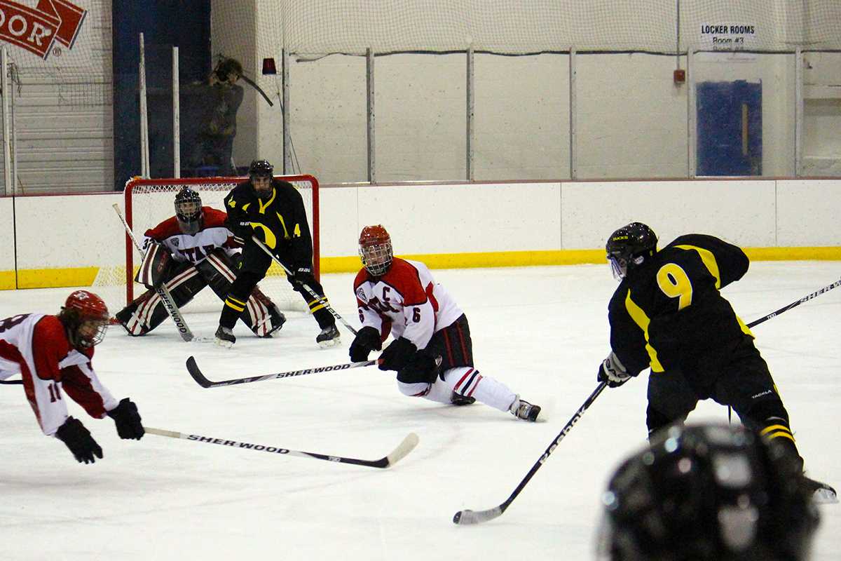 #9 Chris Stankeivicz prepares a slap shot as defenders close in.