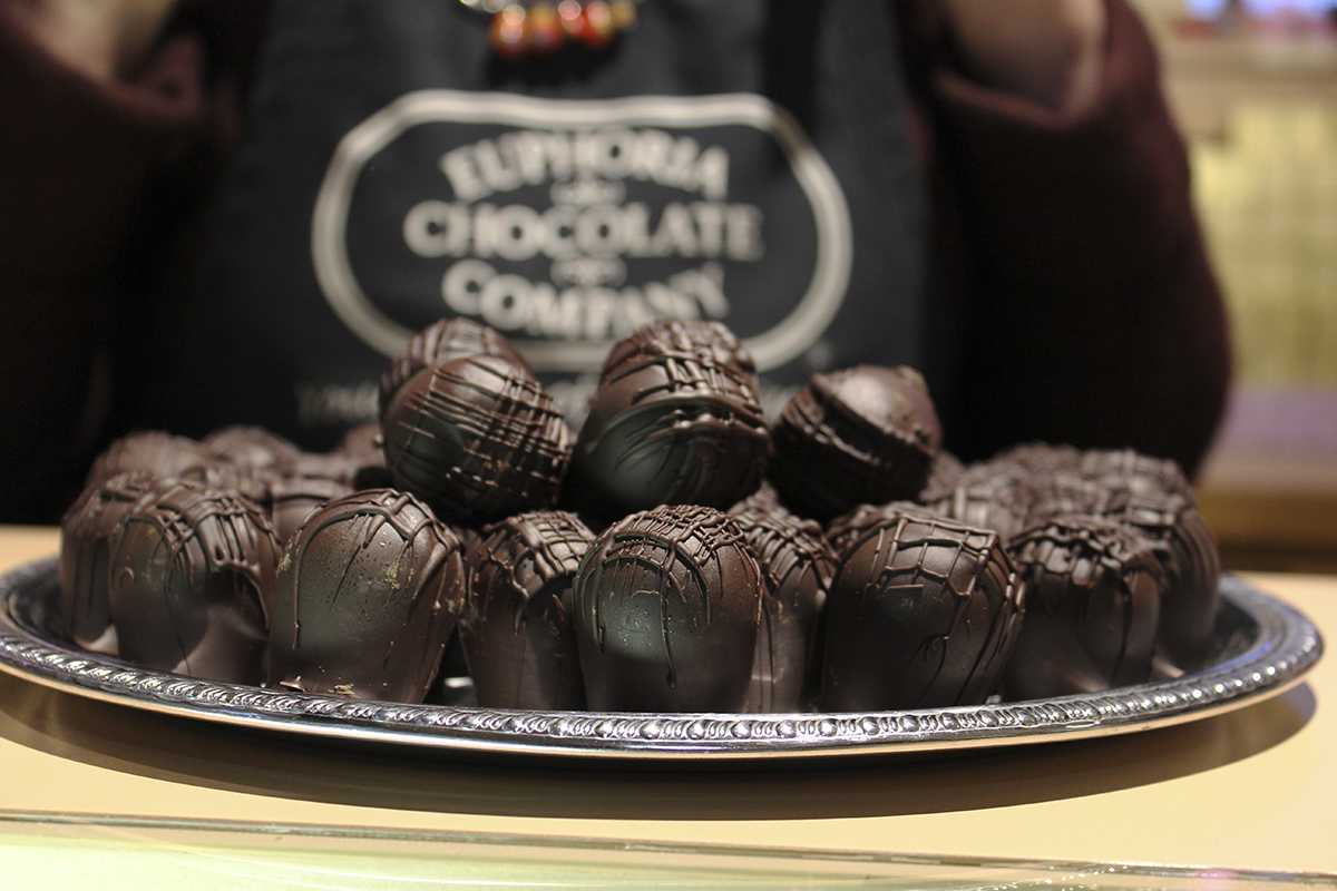 Euphoria Chocolate Company shopkeeper displaying some of the most popular item in the store, Chocolate Truffles.