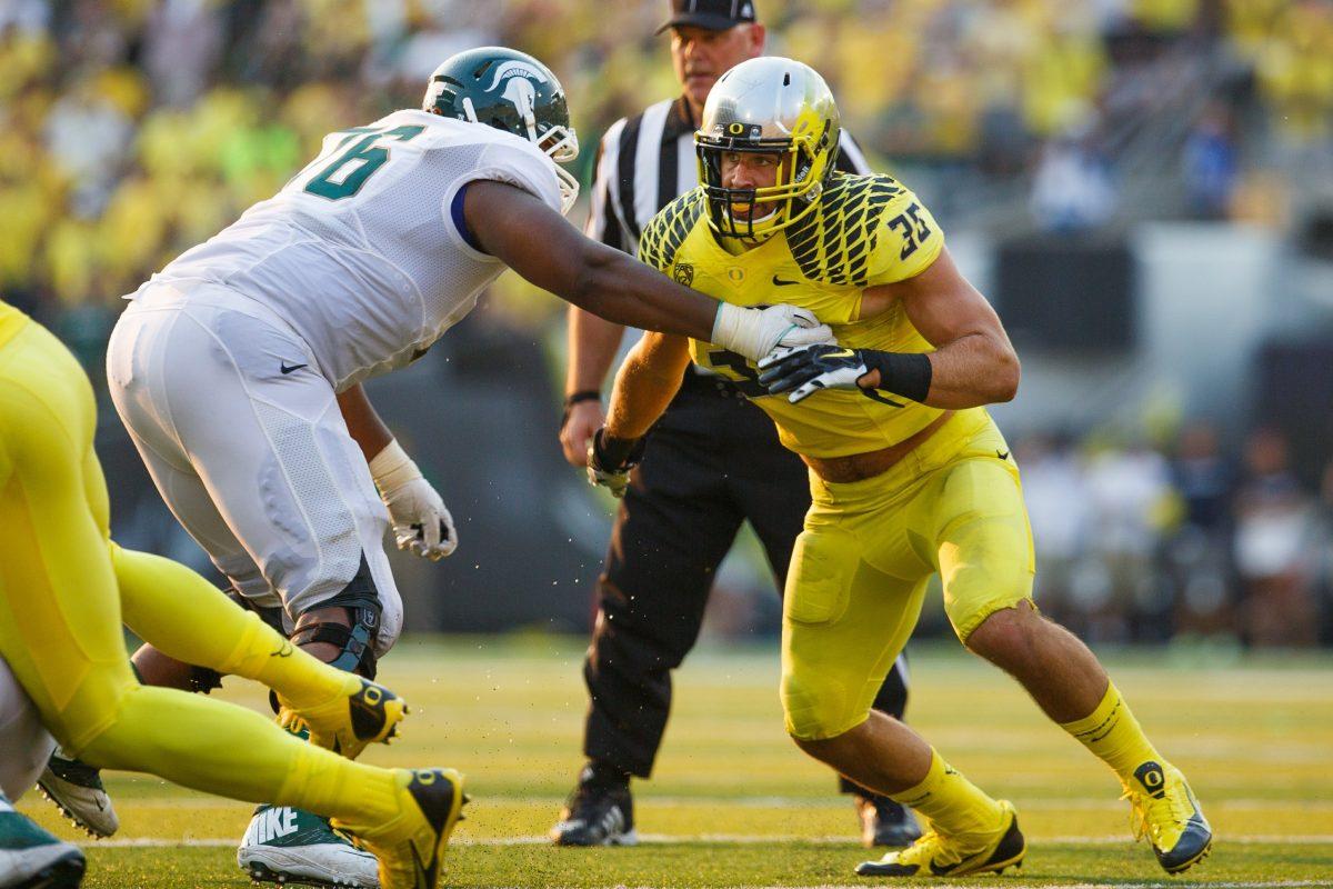 Joe Walker tries to evade a Michigan State lineman in a home game at Autzen Stadium on Sept. 7, 2014 (Taylor Wilder/ Daily Emerald).