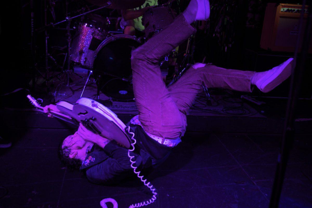 James Alex of Beach Slang tumbles on stage while managing to play his guitar at Portland&#8217;s Analog Theater on Nov. 11. (Meerah Powell/Emerald)