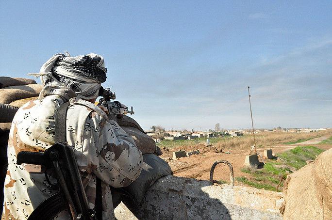 A PUK Peshmerga fighter takes aim at ISIS positions south of Kirkuk near Mula Abdula village on Jan. 31, 2015. (Photo by Mat Wolf)