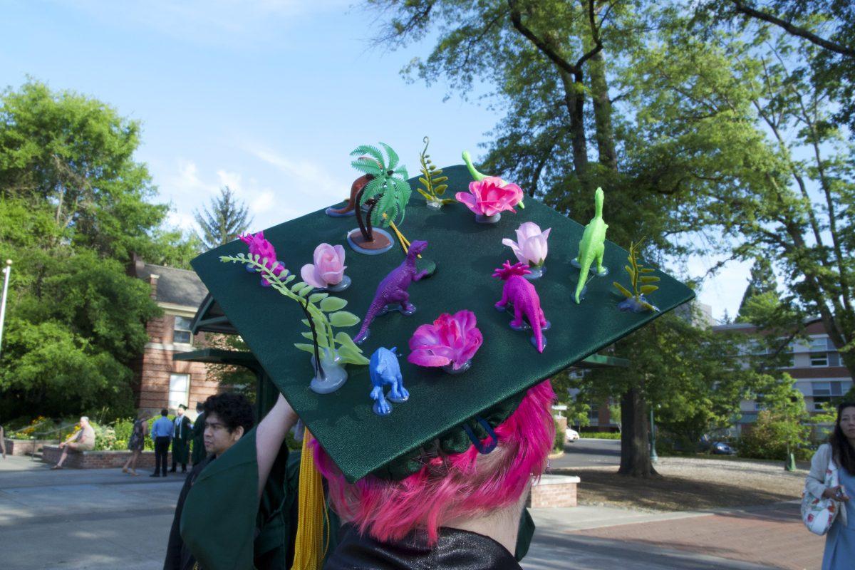 Molly Fullerton, a general science major, decorated her grad cap with a variety of colorful plastic dinosaurs, plants and flowers. (Meerah Powell/Emerald)