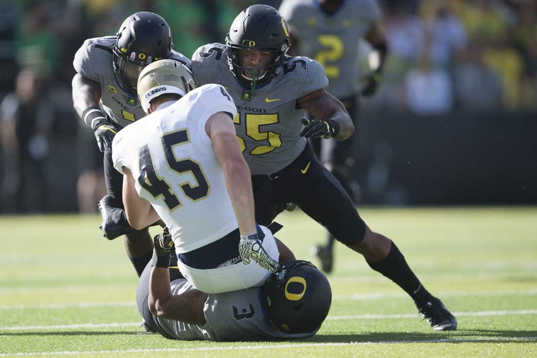 Oregon Ducks defensive back Arrion Springs (1), Oregon Ducks linebacker A.J. Hotchkins (55) and Oregon Ducks linebacker Jonah Moi (3) bring down UC Davis Aggies tight end Wesley Preece (45). The No. 24 Oregon Ducks play the UC Davis Aggies for the season opener at Autzen Stadium in Eugene, Ore. on Sept. 3, 2016. (Adam Eberhardt/Emerald)