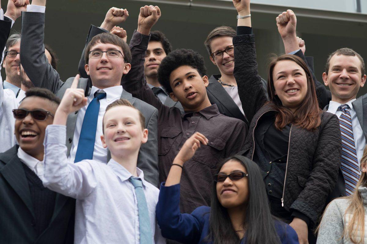 The 21 plaintiffs from the Our Children&#8217;s Trust nonprofit cheer to supporters outside Eugene&#8217;s federal courthouse, during their lawsuit&#8217;s first court hearing in March.