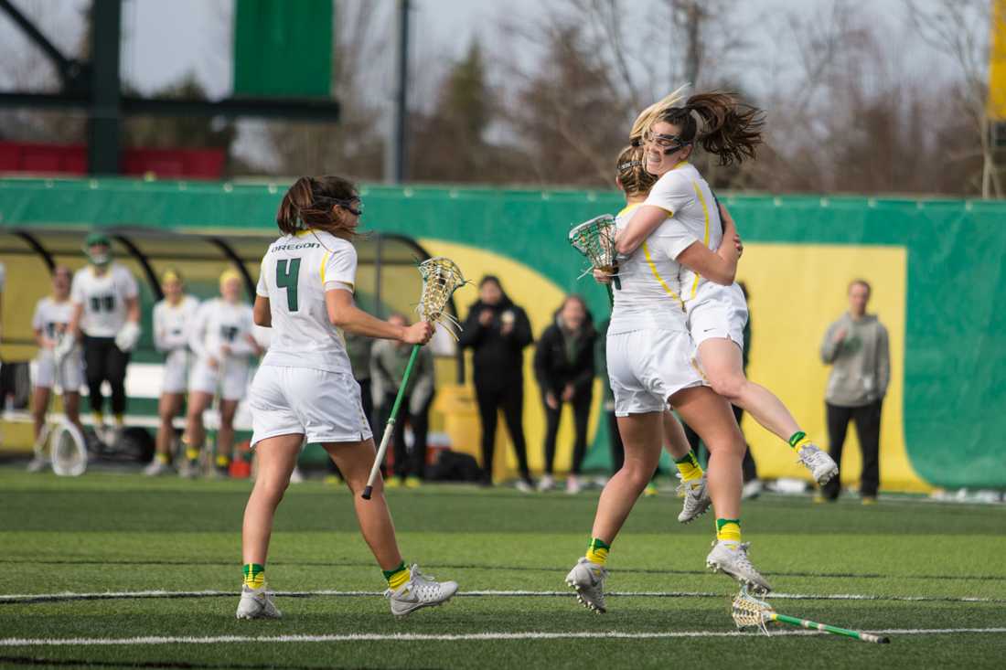 Oregon Ducks midfielder Bella Pyne (14) celebrates with teammates after sinking a shot. The University of Oregon Women&#8217;s Lacrosse team host the California Golden Bears at Pap&#233; Field on Feb. 19, 2015. (Aaron Nelson/Emerald)