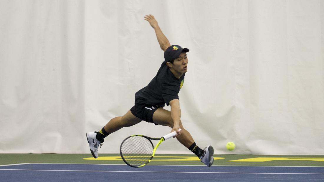 Akihiro Tanaka reaches to hit the ball back to his opponent during the doubles round. The Oregon Ducks play the Iowa Hawkeyes at the Oregon Student Tennis Center in Eugene, Ore. on Saturday, February 11, 2017. (Adam Eberhardt/Emerald)