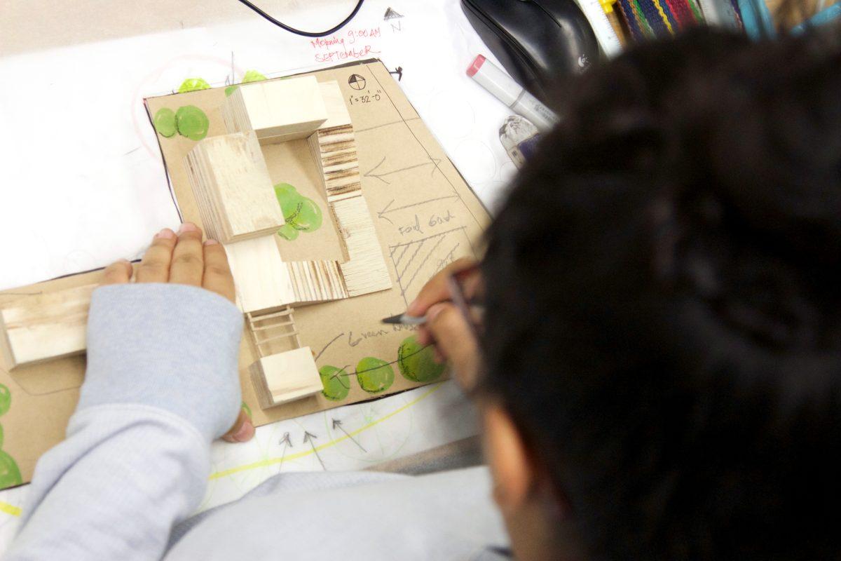 Dristi Manandhar, a University of Oregon architecture student from Kathmandu, Nepal, sits down at her studio desk in the University of Oregon&#8217;s architecture building, Lawrence Hall.