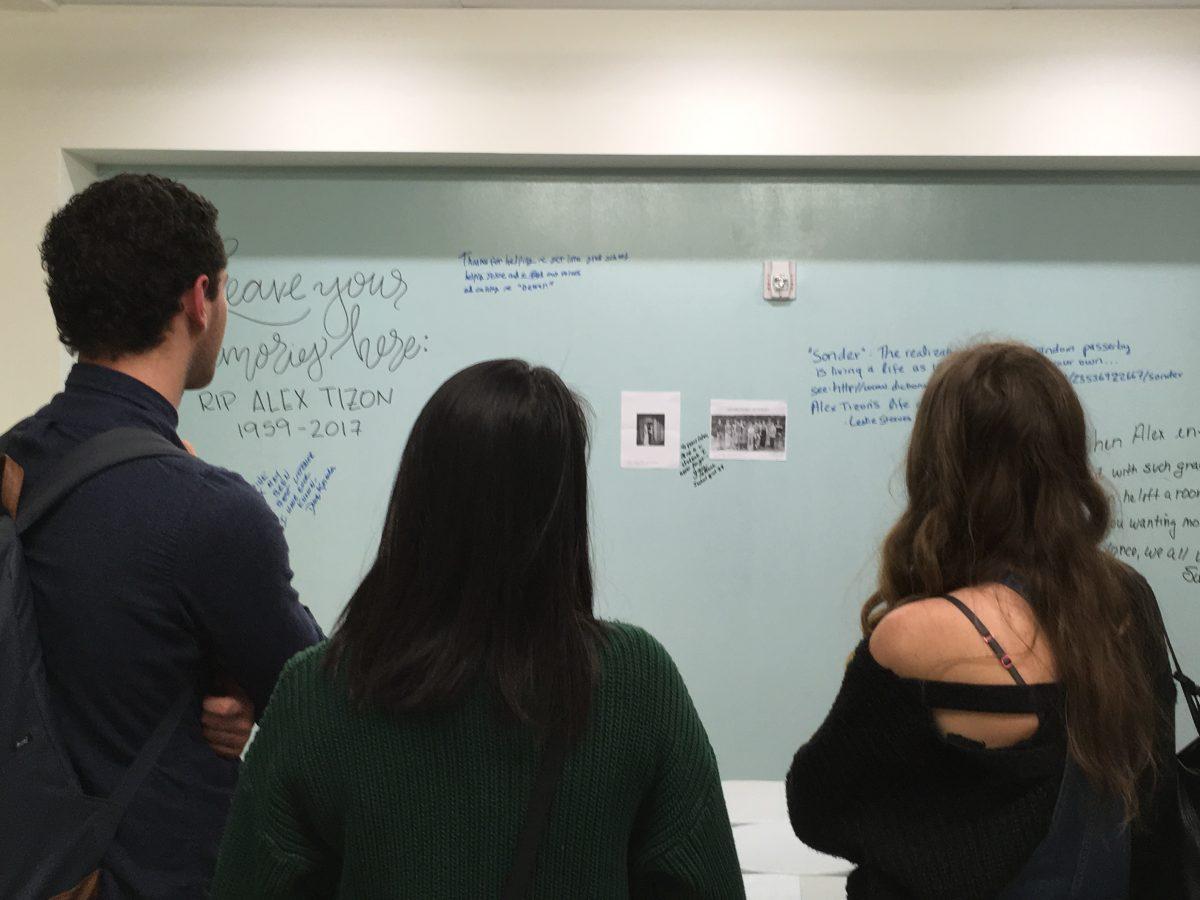 Three students who were in Professor Alex Tizon&#8217;s final &#8220;Reporting II&#8221; class gaze on at messages memorial-goers left on a School of Journalism wall. (Andrew Field/Emerald)