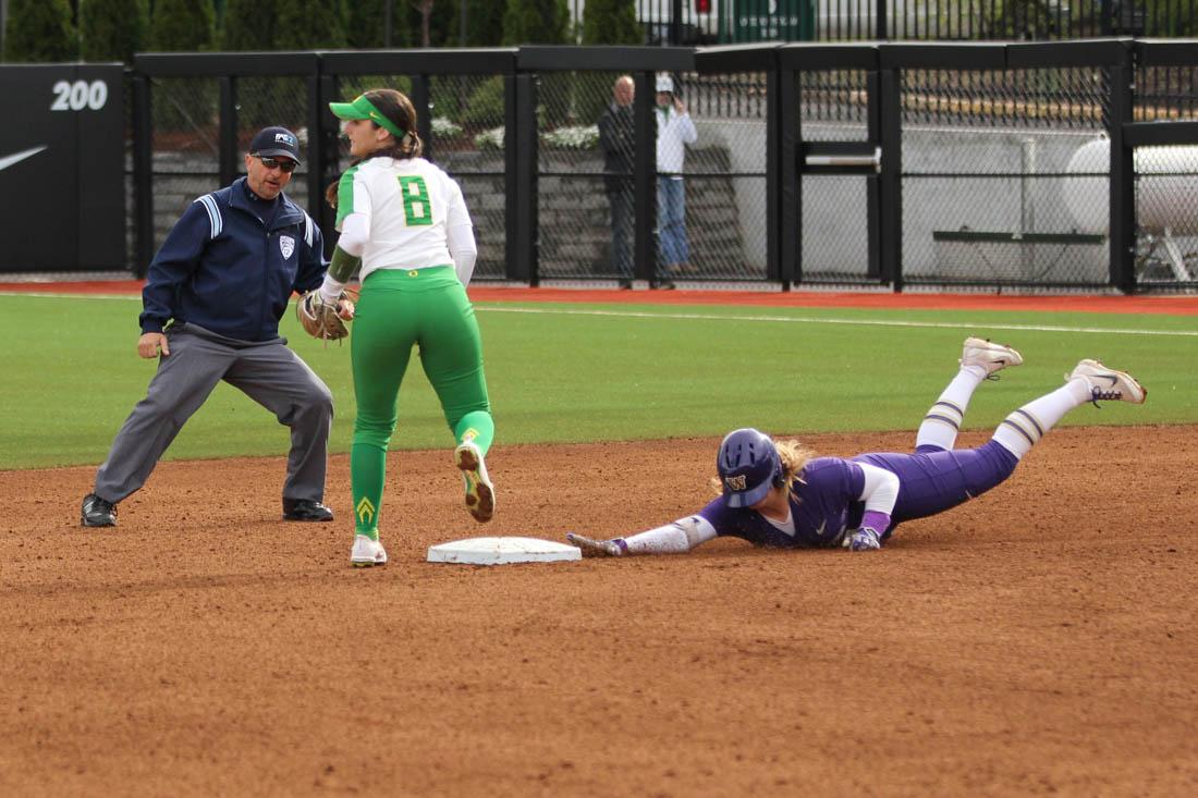 A Huskie players slides into second while second baseman Lauren Lindvall (8) waits for the ball. The Oregon Ducks play the UW Huskies at Jane Sanders Stadium in Eugene, Ore. on April 13, 2017. (Ramsey Sullivan/Emerald)