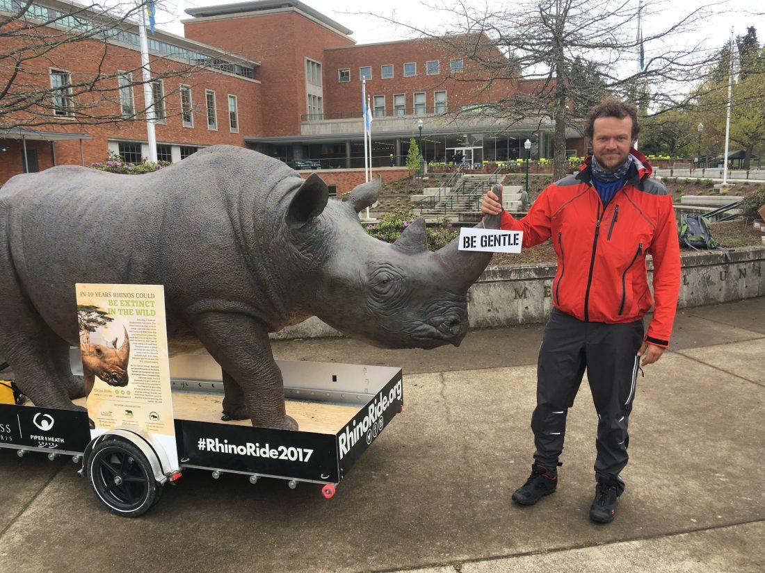 Matt Meyer stands with Lunar, the 350-pound rhinoceros statue he is traveling down the West Coast with to raise awareness about poaching. (Franklin Lewis/Emerald)