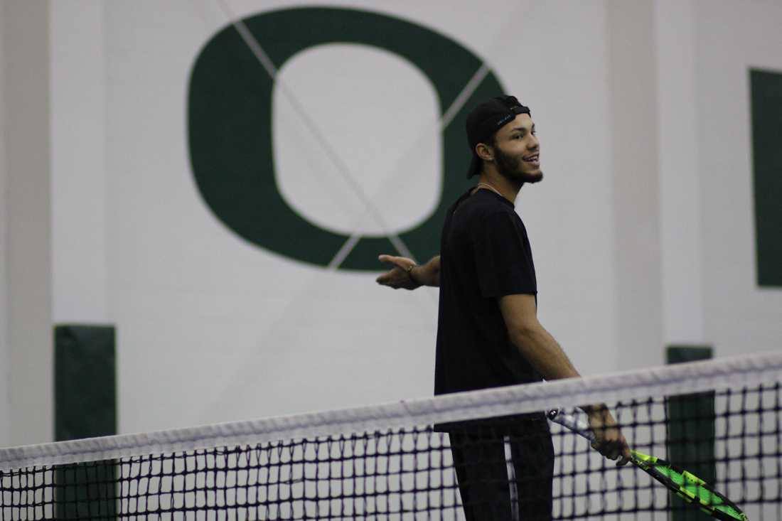 Oregon Ducks Ty Gentry laughs with a teammate during a pause in his singles match. The Oregon Ducks face the Portland State Vikings at the Oregon Student Tennis Center in Eugene, Ore. on January 12, 2018. (Devin Roux/Emerald)