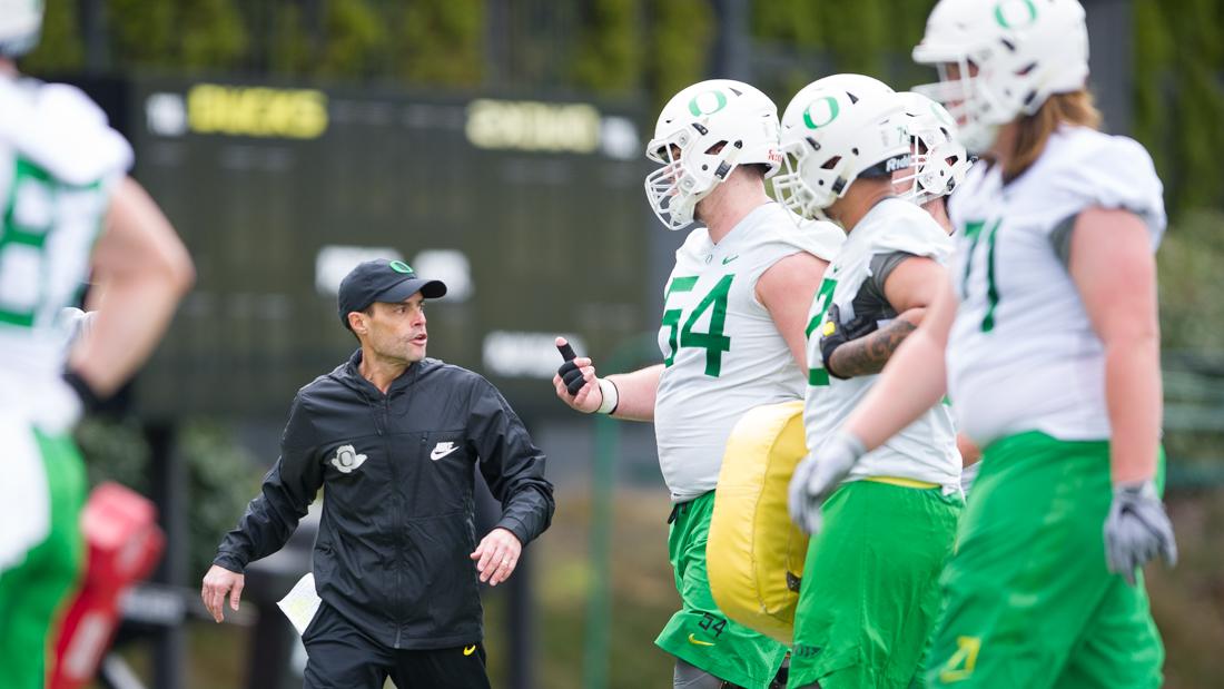 Oregon Centers &amp; Guards Coach Alex Mirabal talks with his players in between drills. The Oregon Ducks hold practice during their spring season at the Hatfield-Dowlin Complex practice fields in Eugene, Ore. on Friday, March 9, 2018. (Adam Eberhardt/Emerald)