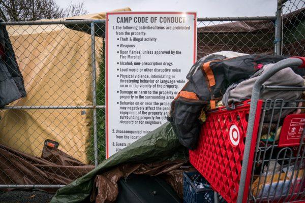 <p>Code of conduct hangs outside of the camp off Highway 99 in Eugene. The camp is the result of a deal struck with the city of Eugene looking for a long term solution for homeless camping. (Dana Sparks/Emerald)</p>