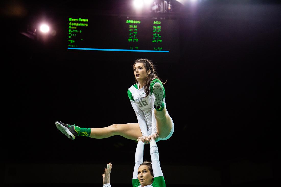 Ducks top Makenna Jarman (36) holds her position in an acro during the team routine. Oregon Ducks acrobatics and tumbling meets with Arizona Christian University at Matthew Knight Arena in Eugene, Ore. on Feb. 23, 2019. (Sarah Northrop/Emerald)