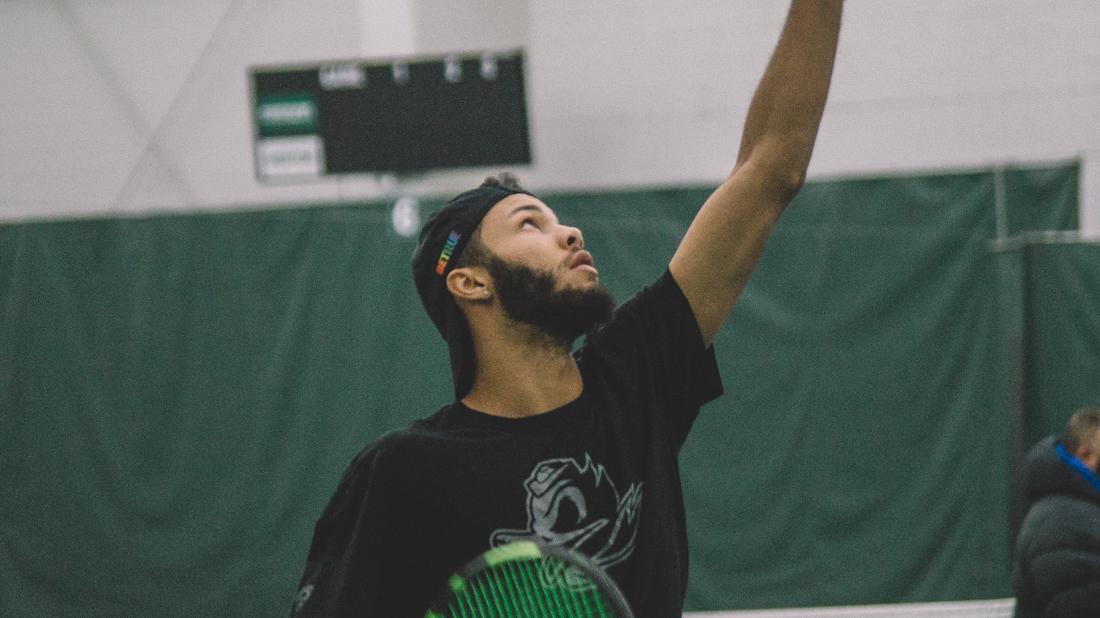 Ty Gentry gazes up at the ball as he is about to serve. Oregon Ducks men&#8217;s tennis takes on Boise State University at the Student Tennis Center in Eugene, Ore. on Feb. 08, 2019. (Connor Cox/Emerald)