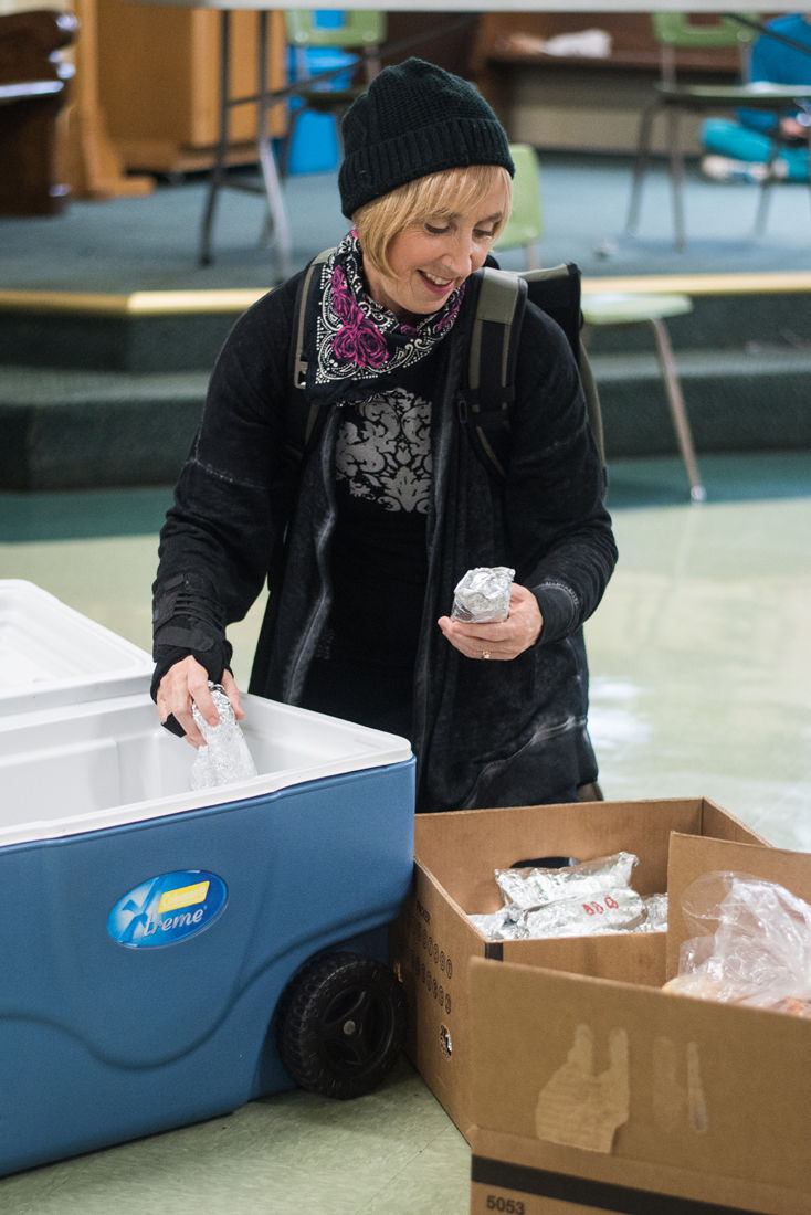 Sally Pravel organizes the coolers and boxes of burritos before departing for distribution. Pravel is a regular volunteer who distributes meals along the Whiteaker route. Burrito Brigade, a non-profit organization that delivers meals to hungry individuals in the Eugene and Springfield by foot, bike, and car, meets to prepare burritos at First Christian Church in downtown Eugene, Ore. on Nov. 17, 2019. (Marissa Willke/Emerald)