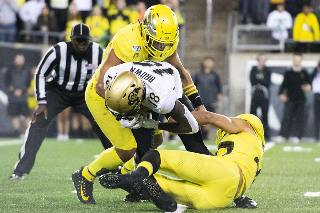 Ducks inside linebacker Isaac Slade-Matautia (41) and inside linebacker Travis Dye (35) tackle a Buffalo for the ball. Oregon Ducks Football takes on the Colorado Buffaloes at Autzen Stadium in Eugene, Ore. on Oct. 11, 2019. (Kimberly Harris/Emerald)