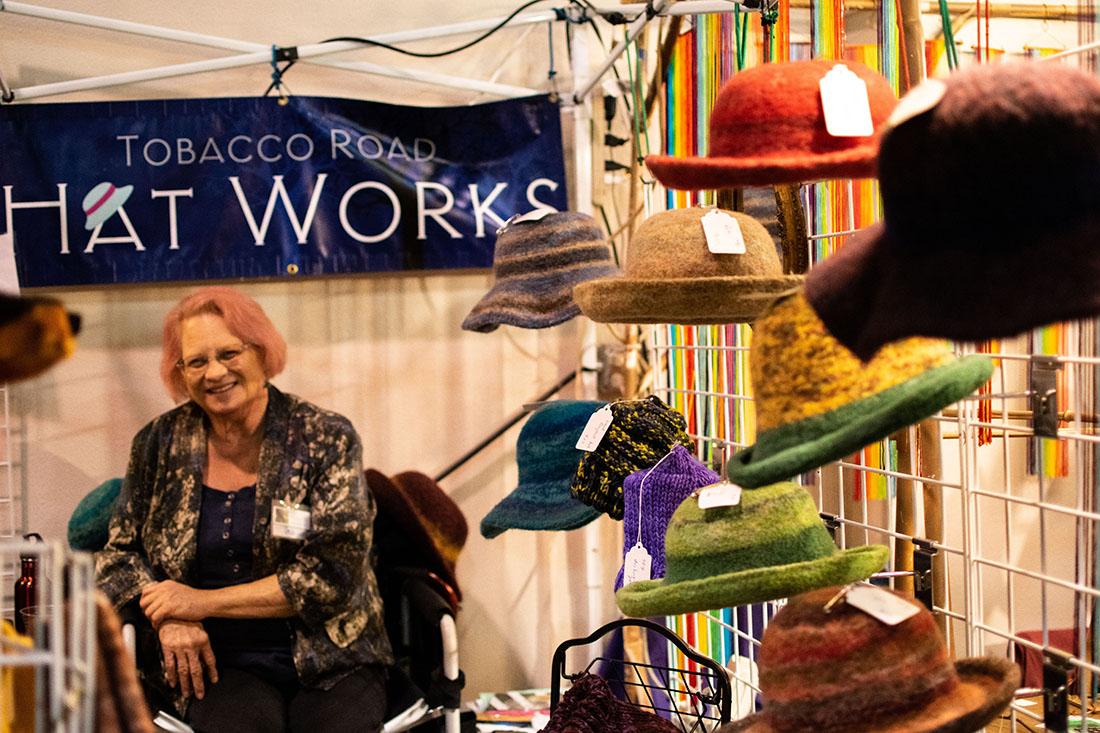 A wool hat vendor sells her crafts at the Eugene Saturday Market&#8217;s Holiday Market. (Kimberly Harris/Emerald)