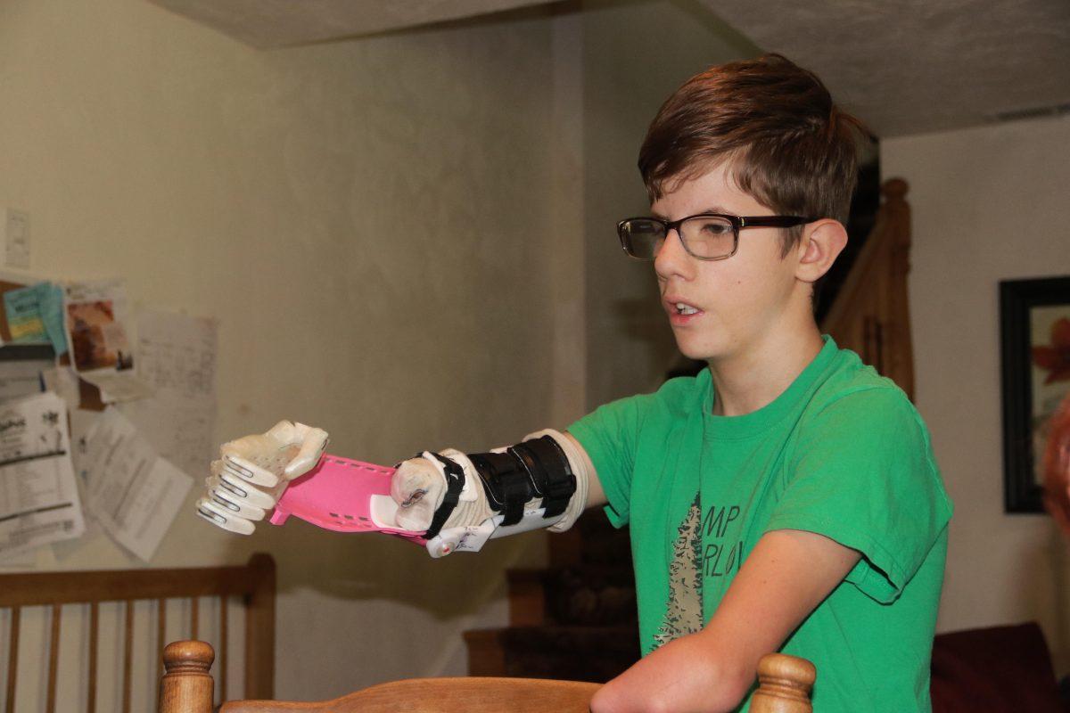 Joseph Horton uses the prototype prosthetic arm the UO BIO team built him last summer. (Courtesy of Ricca Francis)