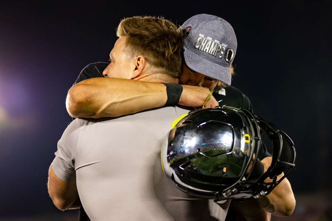 Ducks strength and conditioning coordinator Aaron Feld hugs quarterback Justin Herbert (10) after their Rose Bowl victory. Oregon Ducks football takes on Wisconsin for the 106th Rose Bowl Game at Rose Bowl Stadium in Pasadena, Calif. on Jan. 1, 2020. (Maddie Knight/Emerald)