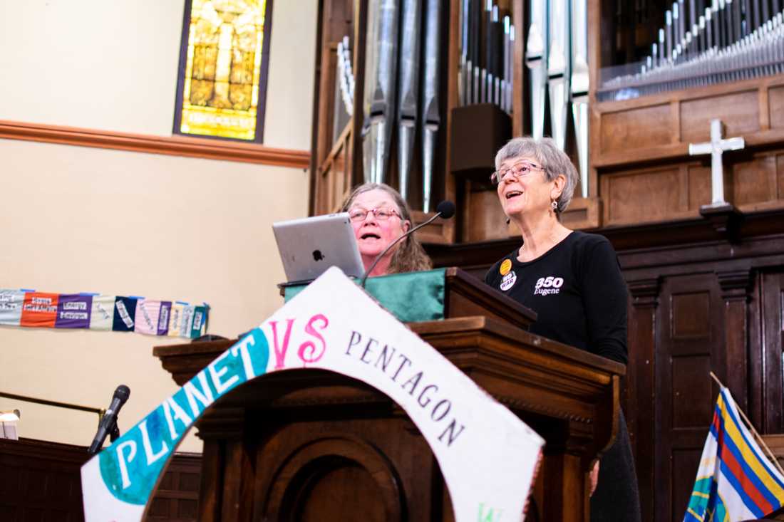 Debra McGee and Patty Hine open the speaking with a song during the Global Day of Protest at First Christian Church. (Kimberly Harris/Emerald)