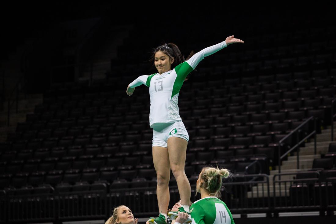 Ducks top Kaylene Iriye (13) checks her balance while going up in an acro. Oregon Ducks acrobatics and tumbling meets with Arizona Christian University at Matthew Knight Arena in Eugene, Ore. on Feb. 23, 2019. (Sarah Northrop/Emerald)