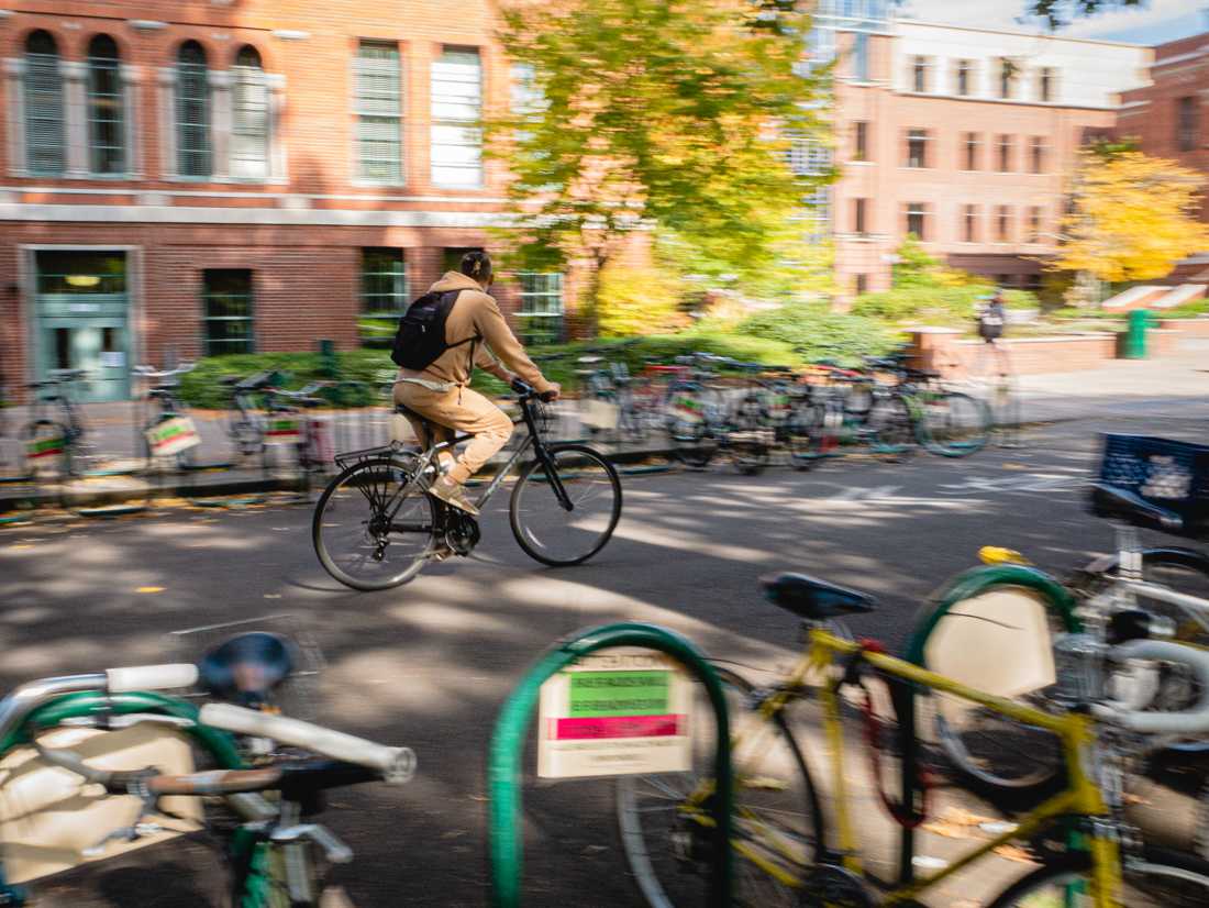 A student rides their bike through the heart of campus. (Connor Cox/Emerald)