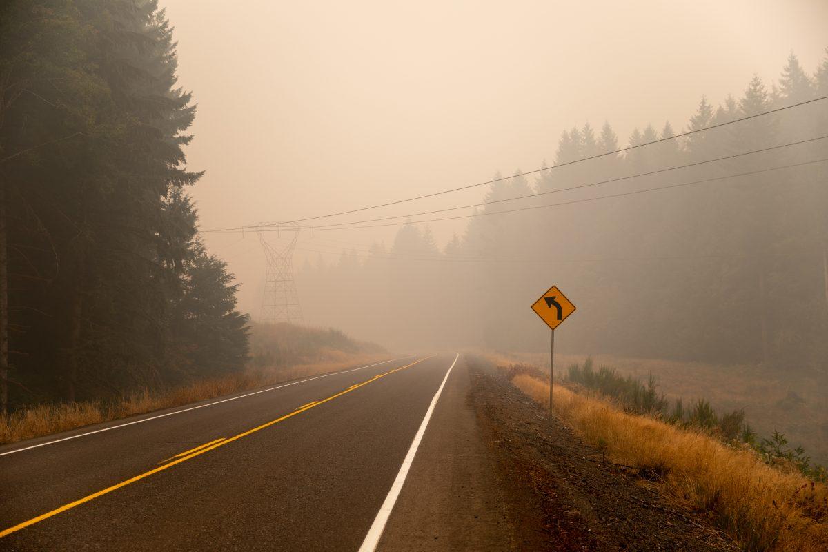 A road that runs along the perimeter of the Holiday Farm Fire zone in Marcola, Ore. is heavy with smoke. The Holiday Farm Fire, one of the largest current wildfires in Oregon, began on Sep. 7, 2020 and has burned through multiple Oregon cities in over one week. The fire is still burning through Lane County, Ore. on Sep. 16, 2020. (Maddie Knight/Emerald)