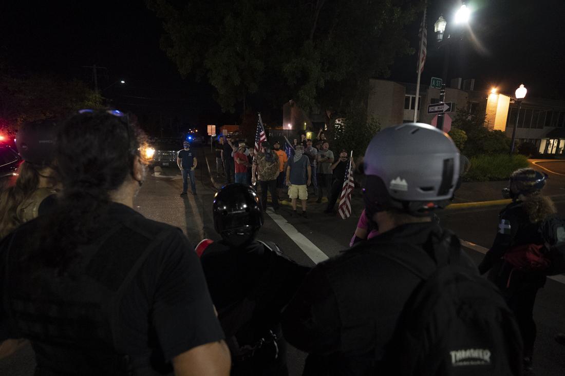 <p>Protesters create a wall of people to distance the counter-protesters from interfering with the speeches. Black Unity held a march for the anniversary of the Elaine Massacre on Wednesday night, Sept. 30, 2020, in Springfield, Ore. Springfield Police escorted the peaceful march and separated confrontation between protesters and counter-protesters. (Kevin Wang/Daily Emerald)</p>