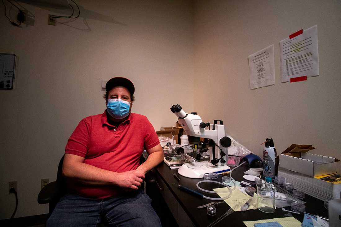 Joshua Razink poses at his workstation in Huestis Hall. University employees on campus are concerned about the lack of mandatory COVID-19 testing, as well as the inability to access free testing services that students receive. (Will Geschke/Emerald)