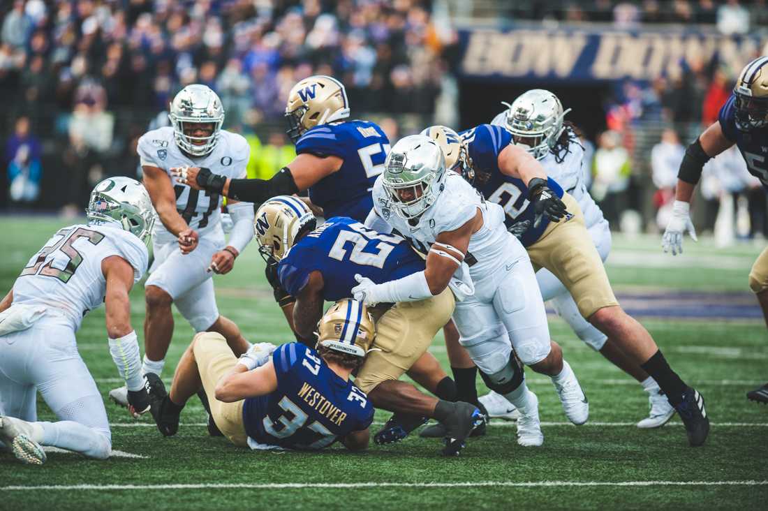 Ducks outside linebacker Mase Funa (45) tackles the Husky's tailback Salvon Ahmed (26). Oregon Ducks Football takes on the University of Washington Huskies at Husky Stadium in Seattle, Wash. on Oct. 19, 2019. (DL Young/Emerald)