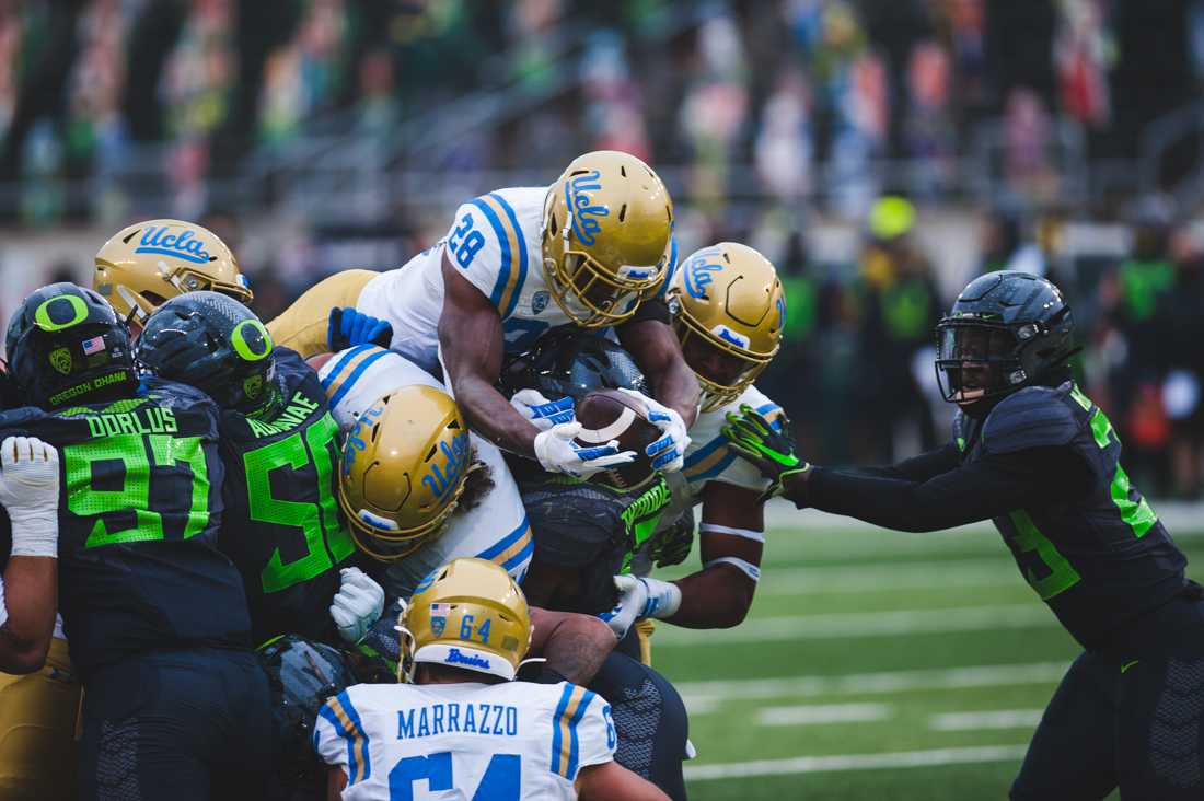 <p>Bruins running back Brittain Brown (28) dives over the pile up for the touchdown. Oregon Ducks football takes on the UCLA Bruins at Autzen Stadium in Eugene, Ore., on Nov. 21, 2020. (DL Young/Emerald)</p>