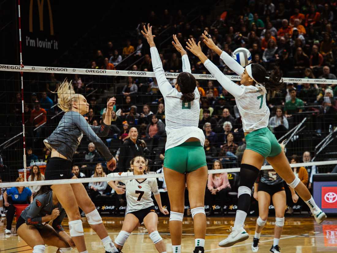 Two Ducks players rise up to block the ball. Oregon Ducks Volleyball takes on Oregon State University at Mathew Knight Arena in Eugene, Ore. on November 29, 2019. (Connor Cox/Emerald)