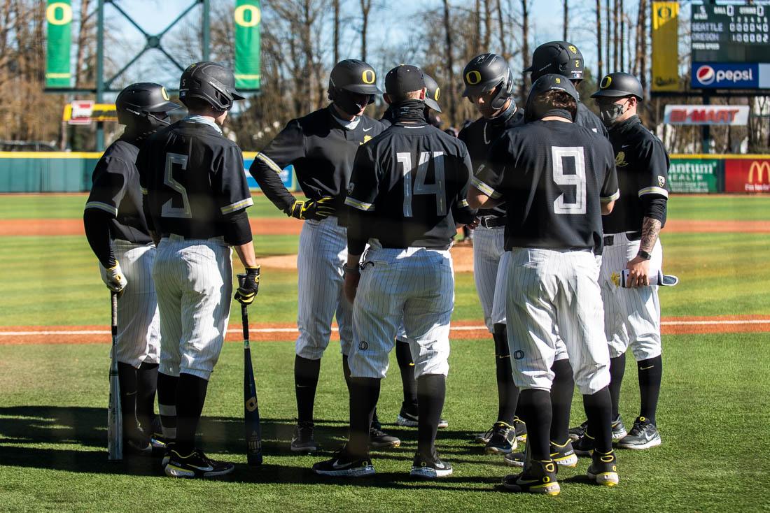 Ducks players in the field gather together after the sixth inning. Oregon Ducks baseball takes on the Seattle University RedHawks at PK Park in Eugene, Ore., on Feb 28. 2021. (Ian Enger/Emerald)