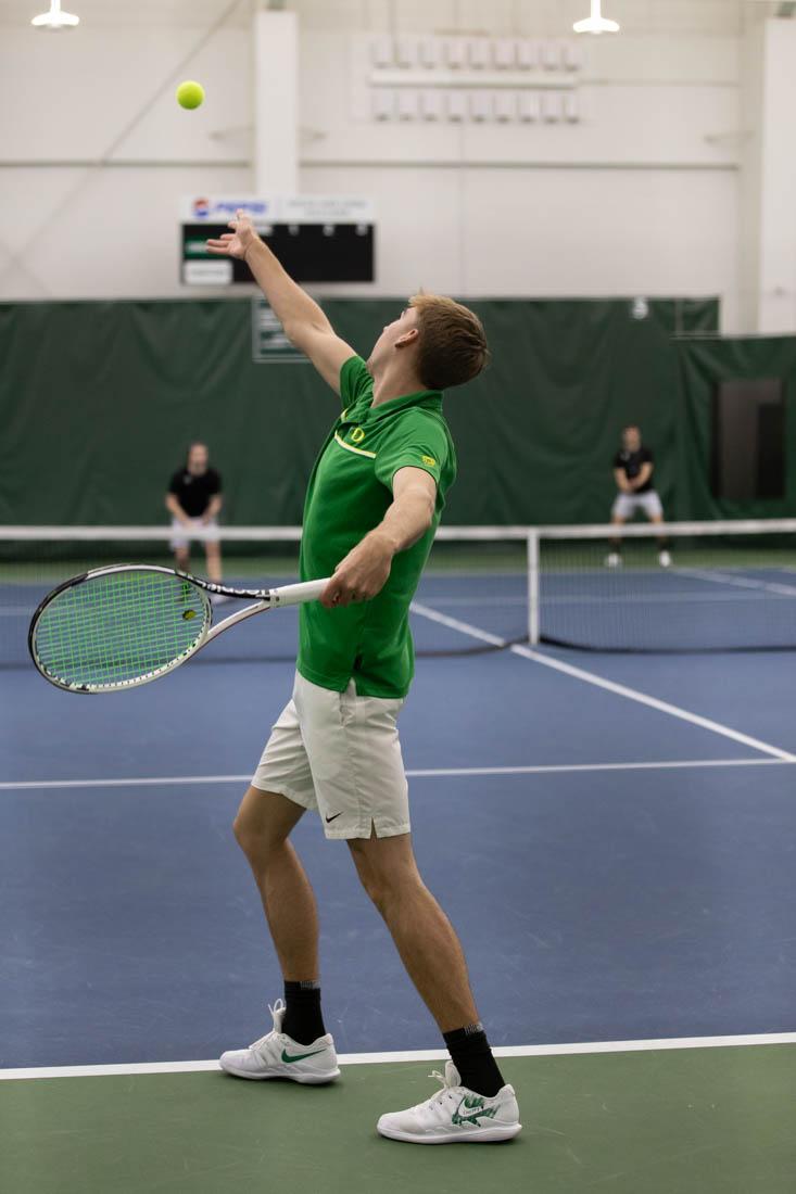 Ducks junior Joshua Charlton throws the ball up for a serve. Oregon Ducks men's tennis take on Portland State Vikings at the Student Tennis Center on Feb. 06, 2021. (Maddie Stellingwerf/Emerald)