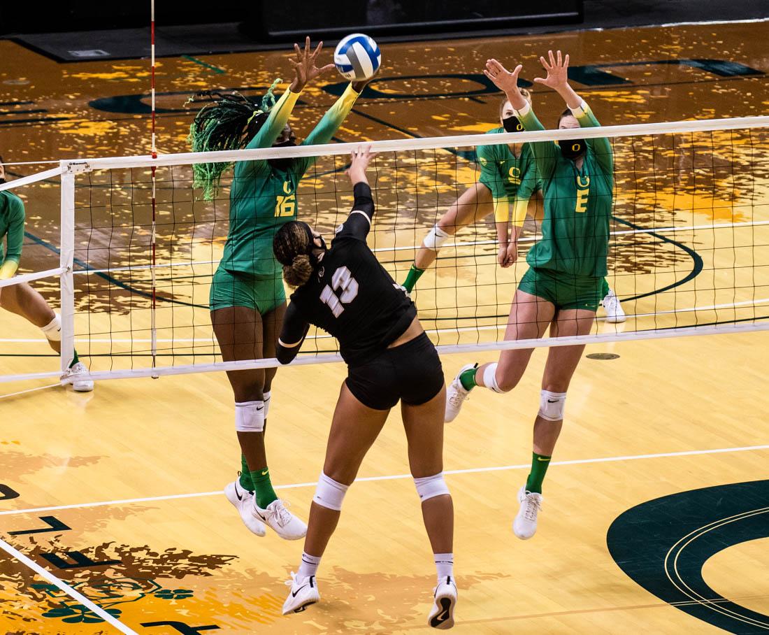 Ducks players Gloria Mutiri (16) and Taylor Williams (8) both jump to block the ball. Oregon Ducks women&#8217;s volleyball takes on the Colorado Buffaloes at Matthew Knight Arena in Eugene, Ore., on Feb 26, 2021. (Ian Enger/Emerald)