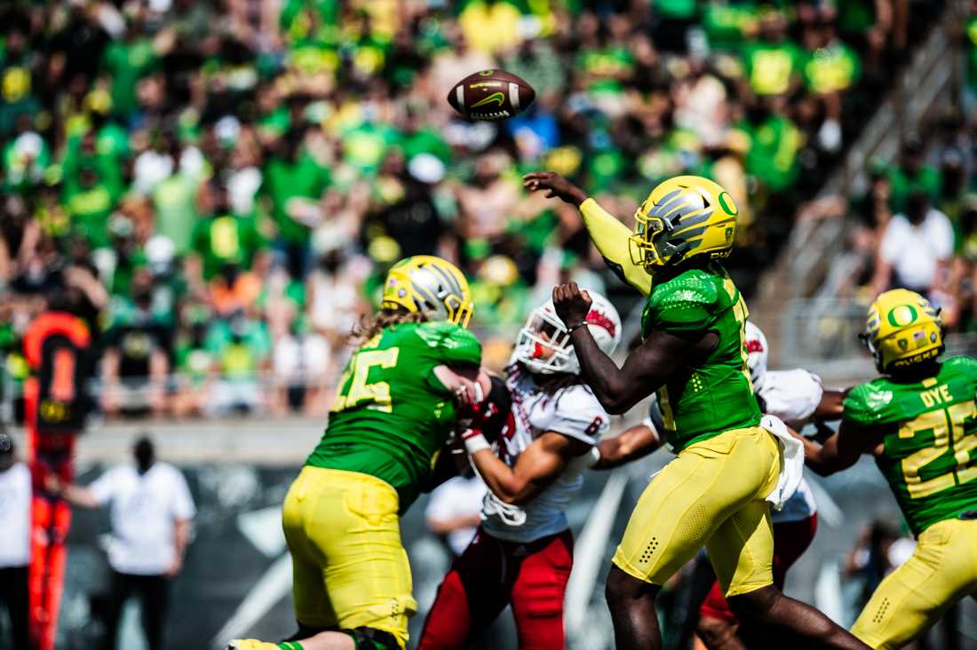 Ducks quarterback Anthony Brown (13) throws the ball to his teammate while other players clash. The Oregon Ducks host Fresno State on September 4th, 2021, for game one of the 2021 season.