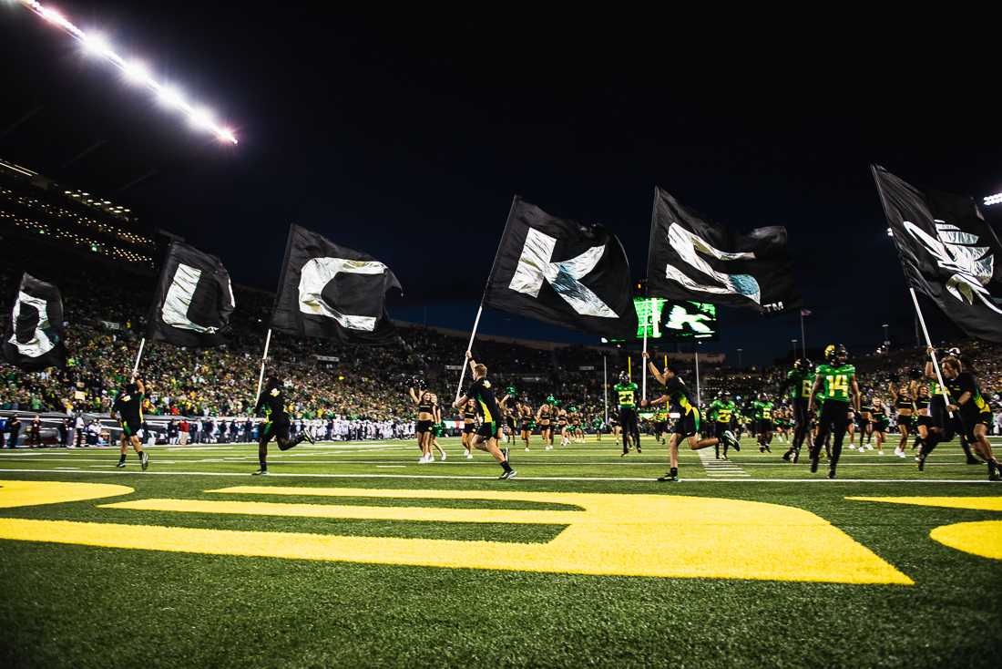 Oregon football players and cheerleaders rush to the field at the beginning of Saturday night&#8217;s game at Autzen Stadium against the Arizona Wildcats. The Oregon Ducks crush the Arizona Wildcats 41-19 in game four of the 2021 season. (Ian Enger/ Emerald)