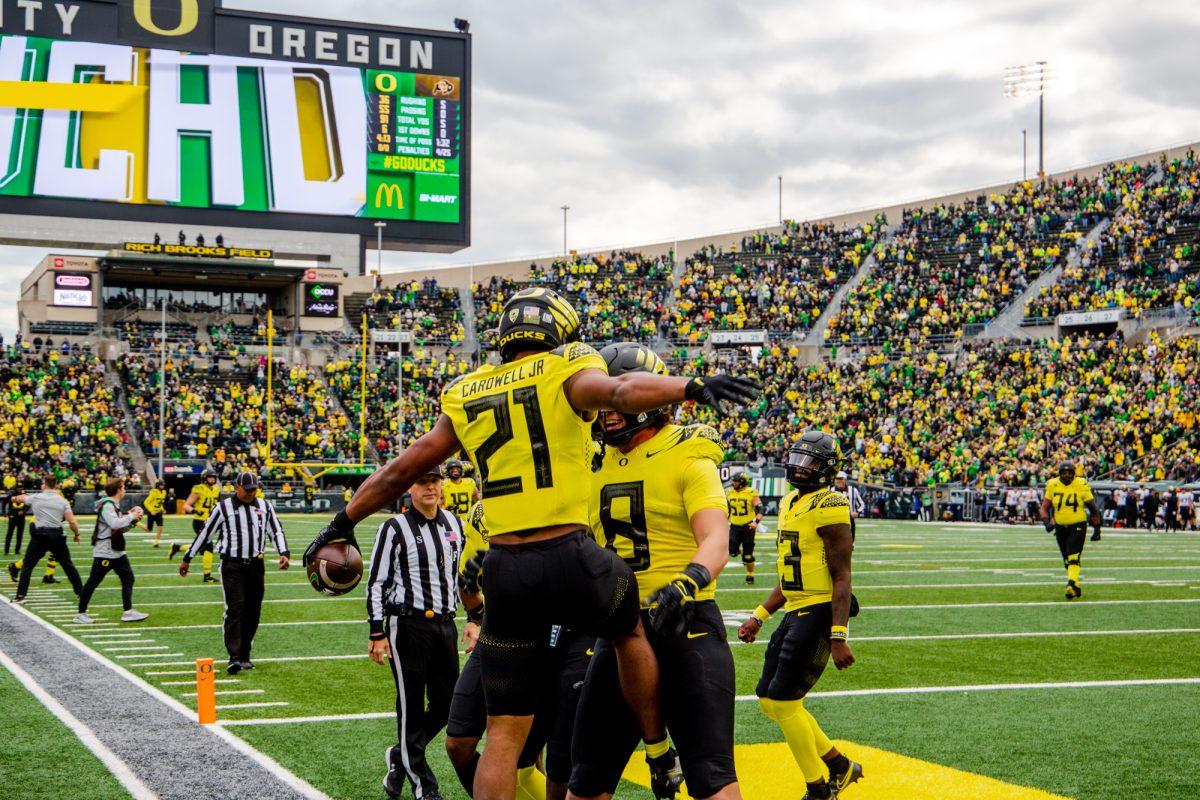 Byron Cardwell (21) celebrates with Moliki Mavato (8) after scoring a touchdown for Oregon. The University of Oregon Ducks defeated the University of Colorado Buffaloes 52-29 at Autzen Stadium on October 30, 2021. (Will Geschke/Emerald)