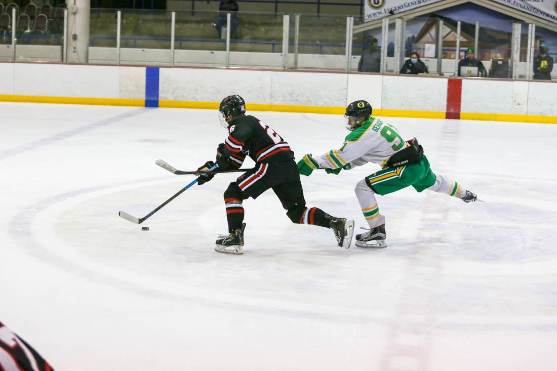 Jack Geraghty (91) catches up with his opponent to take control of the puck. Oregon Ducks play San Diego State Aztecs on a cold October night. (Ali Watson/Emerald)