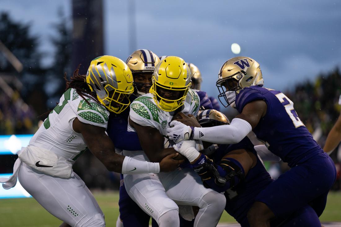 Oregon Quarterback, Anthony Brown Jr. tries to stay on his feet as he carries the ball forward in an attempt to gain yards. The Oregon Ducks take on the Washington Huskies at Husky Stadium in Seattle, Wash., on November 6, 2021. (Serei Hendrie/Emerald)